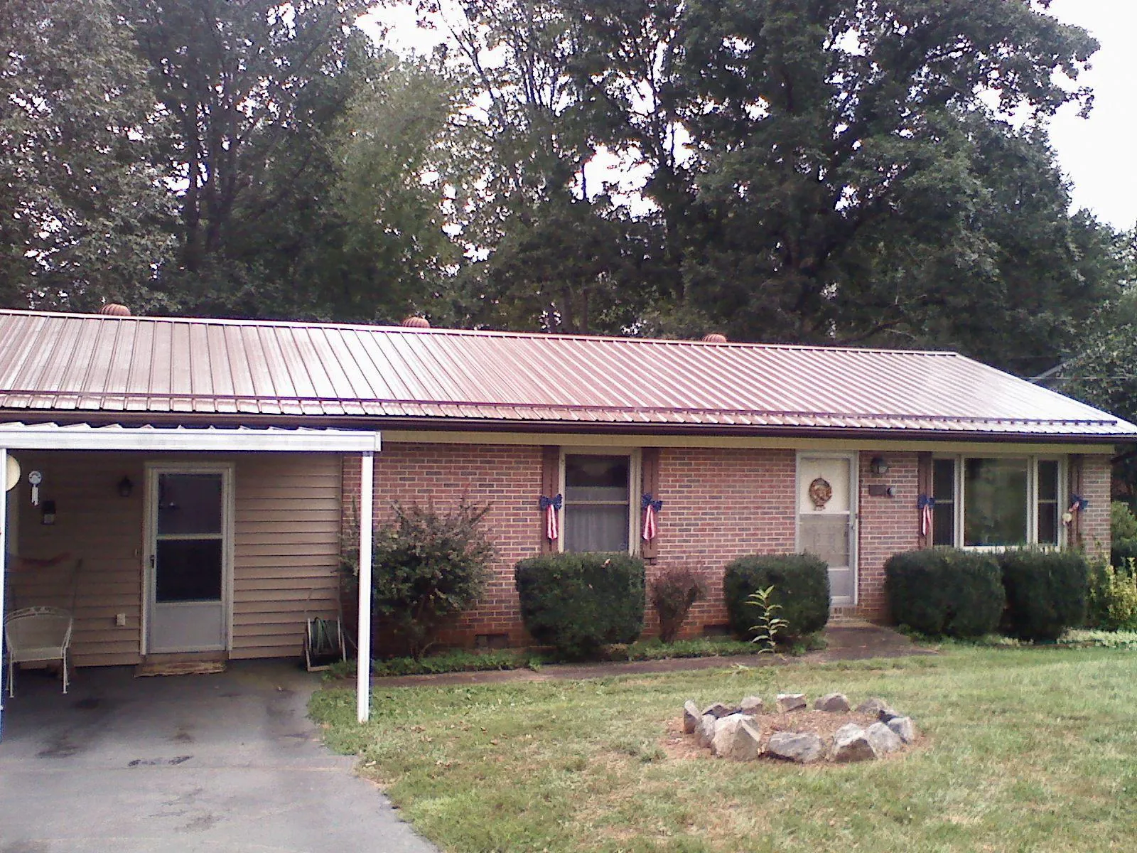 Bronze metal roof and carport on a brick ranch home — Roof Repair work by our crew in Parsonsburg